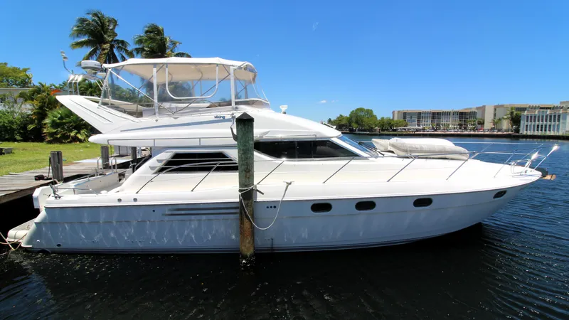 Slide: The Image of 1997 Viking Sport Cruisers 48SC yacht docked by palm trees and buildings. - 1