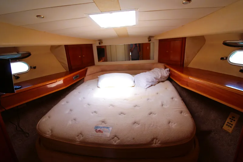 Slide: The Image of 1997 Viking Sport Cruisers 48SC cabin with a cozy bed and wooden interior. - 12