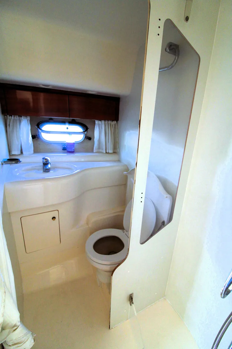 Slide: The Image of 1997 Viking Sport Cruisers 48SC yacht bathroom with toilet, sink, and porthole window. - 16