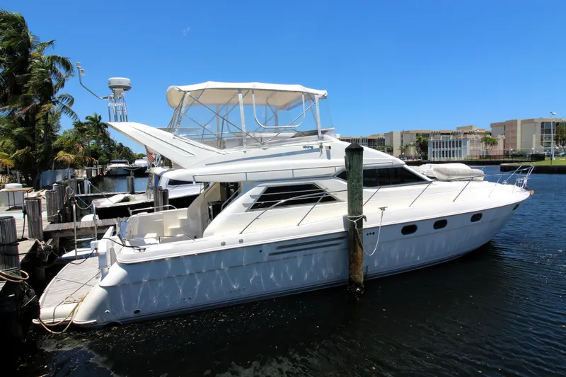 Slide: The Image of 1997 Viking Sport Cruisers 48SC yacht docked by the waterfront under a clear blue sky. - 18