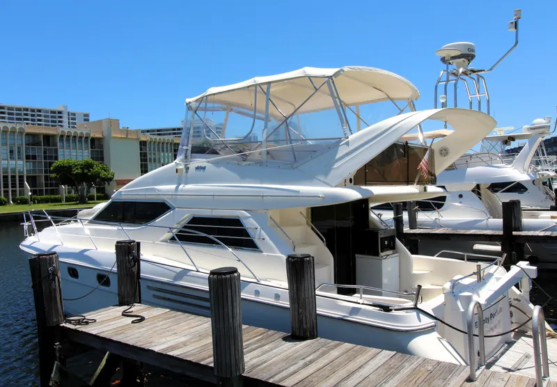 Slide: The Image of 1997 Viking Sport Cruisers 48SC yacht docked at marina under clear blue sky. - 19