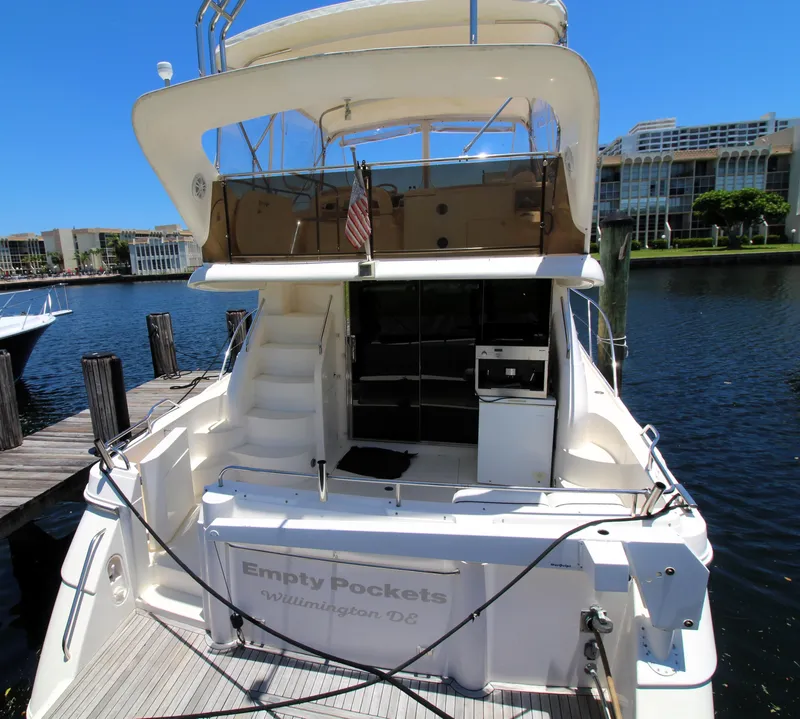 Slide: The Image of 1997 Viking Sport Cruisers 48SC yacht docked, rear view with open deck and stairs. - 2