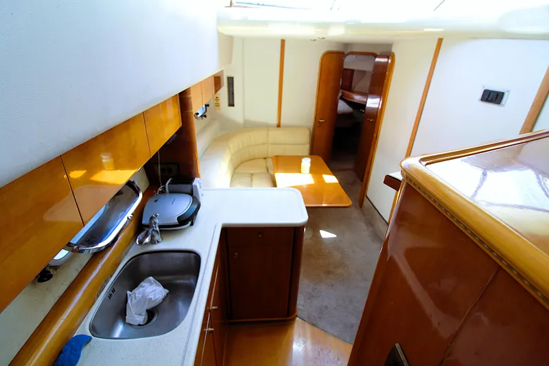 Slide: The Image of Interior of 1997 Viking Sport Cruisers 48SC yacht, featuring kitchen and seating area. - 8