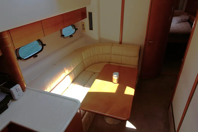 Slide: The Image of 1997 Viking Sport Cruisers 48SC interior with beige seating and wooden table. - 9