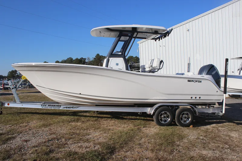 Slide: The Image of 2025 Sea Fox 248 Commander boat on trailer, parked outdoors near a white building. - 3
