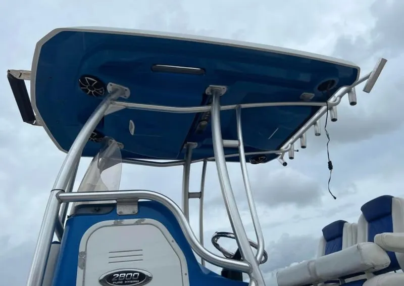 Slide: The Image of 2019 Blue Wave 2800 Pure Bay boat with T-top and seating, under cloudy sky. - 10