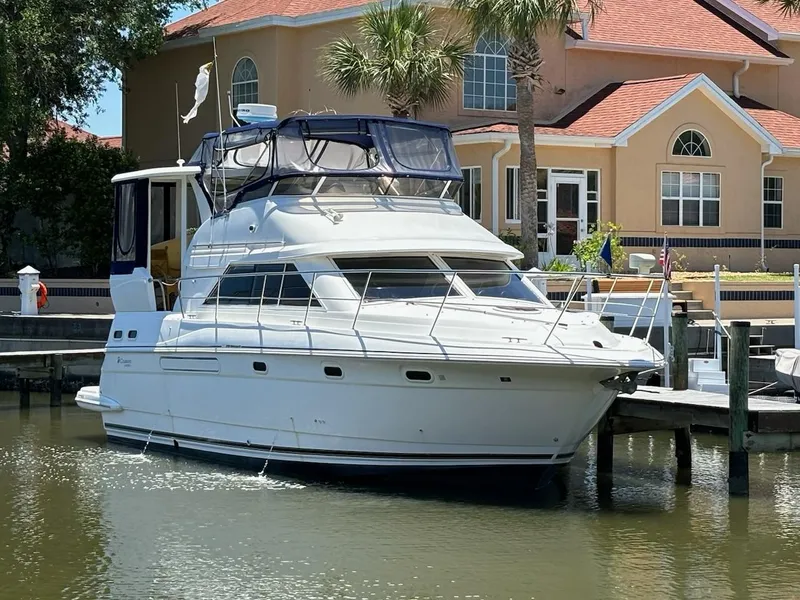 The Image of 1999 Cruisers Yachts 3750 Motoryacht docked near a waterfront home. - 0