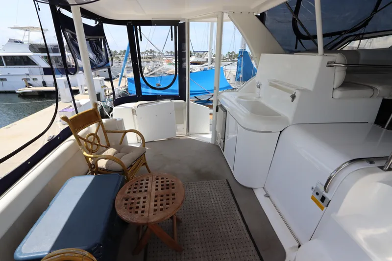 Slide: The Image of 1999 Cruisers Yachts 3750 Motoryacht interior with seating, table, and marina view. - 14