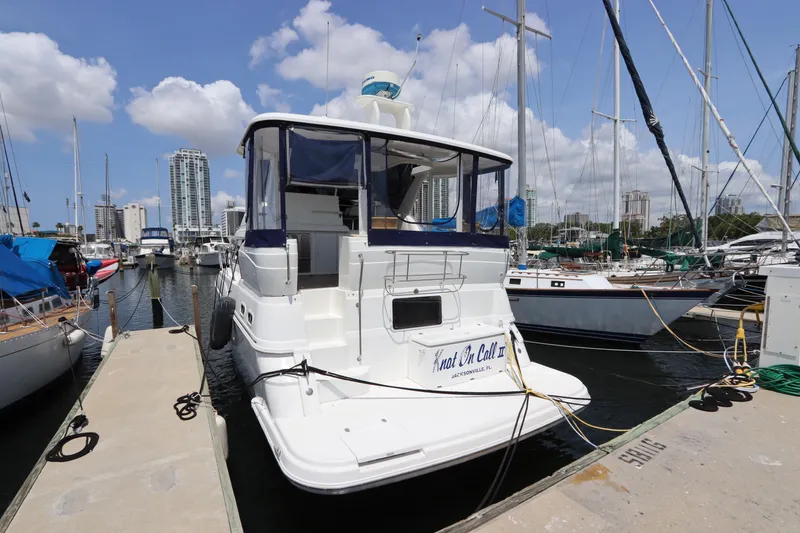 Slide: The Image of 1999 Cruisers Yachts 3750 Motoryacht docked at marina under blue sky. - 3