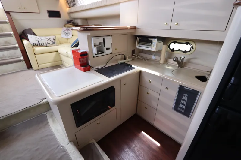 Slide: The Image of 1999 Cruisers Yachts 3750 Motoryacht interior kitchen with modern appliances and cozy seating area. - 31