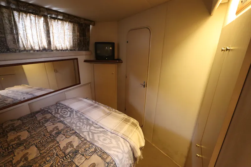 Slide: The Image of 1999 Cruisers Yachts 3750 Motoryacht cabin with bed, TV, and mirror. - 44