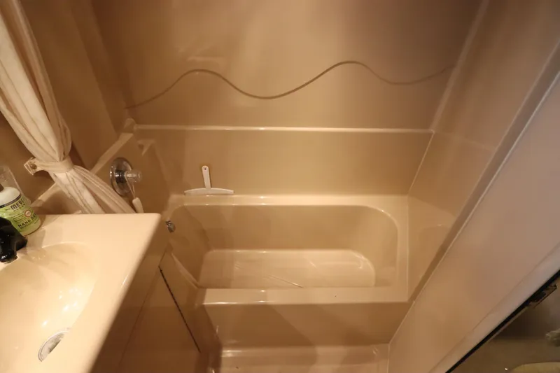 Slide: The Image of Bathroom interior of 1999 Cruisers Yachts 3750 Motoryacht, featuring a compact bathtub. - 48