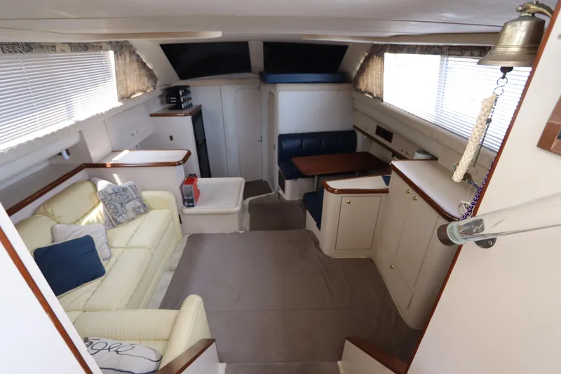 Slide: The Image of 1999 Cruisers Yachts 3750 Motoryacht interior with beige seating and dining area. - 25