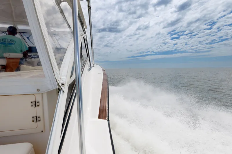 Slide: The Image of 2002 Albemarle 41 Express Fisherman cruising on open water under a partly cloudy sky. - 13