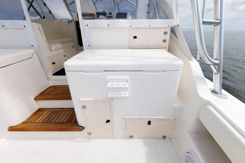 Slide: The Image of 2002 Albemarle 41 Express Fisherman boat interior with white seating and wooden steps. - 18