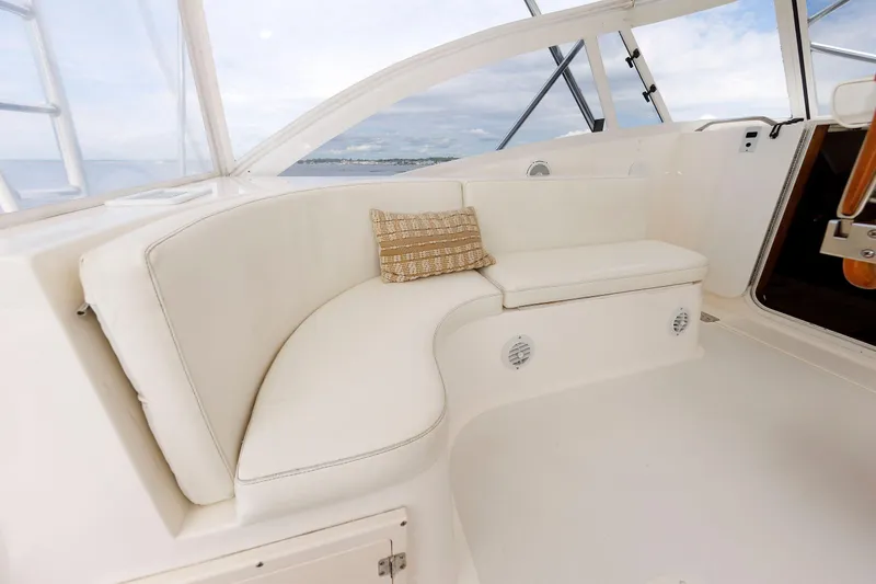 Slide: The Image of 2002 Albemarle 41 Express Fisherman boat interior with white seating and a decorative pillow. - 23