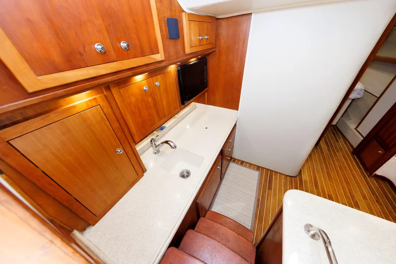 Slide: The Image of 2002 Albemarle 41 Express Fisherman interior with wooden cabinetry and compact kitchen area. - 31