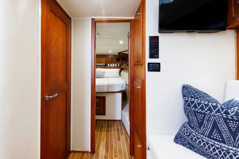 Slide: The Image of 2002 Albemarle 41 Express Fisherman interior with wood finish, cozy cabin, and patterned cushions. - 35