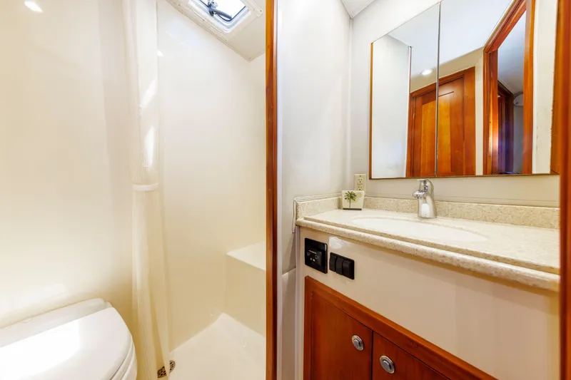 Slide: The Image of 2002 Albemarle 41 Express Fisherman bathroom with shower, sink, and wooden cabinetry. - 41
