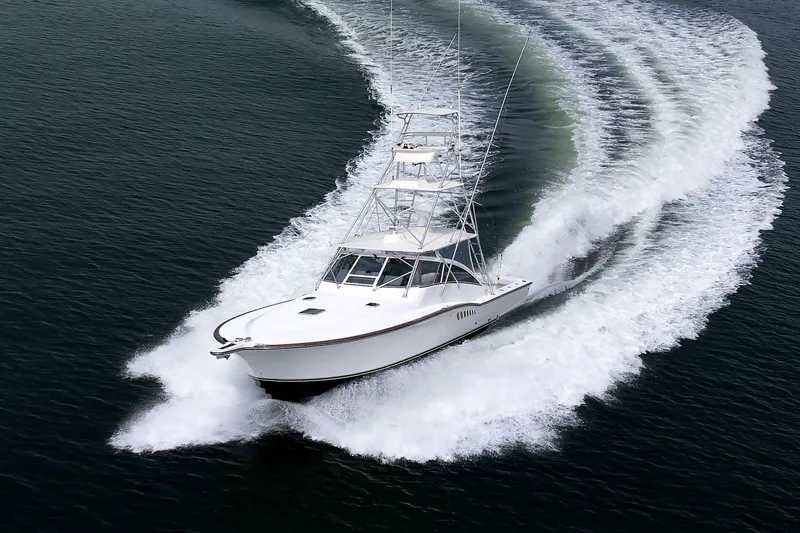 Slide: The Image of 2002 Albemarle 41 Express Fisherman cruising on open water, creating a dynamic wake. - 46
