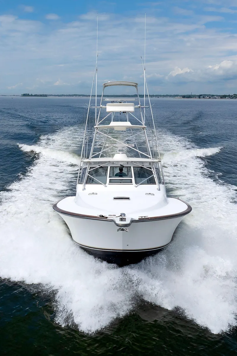 Slide: The Image of 2002 Albemarle 41 Express Fisherman cruising on open water, creating a dynamic wake. - 48