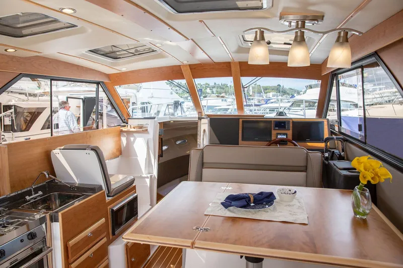 Slide: The Image of Interior of 2025 Cutwater 32 Coupe yacht, featuring modern kitchen and dining area. - 4