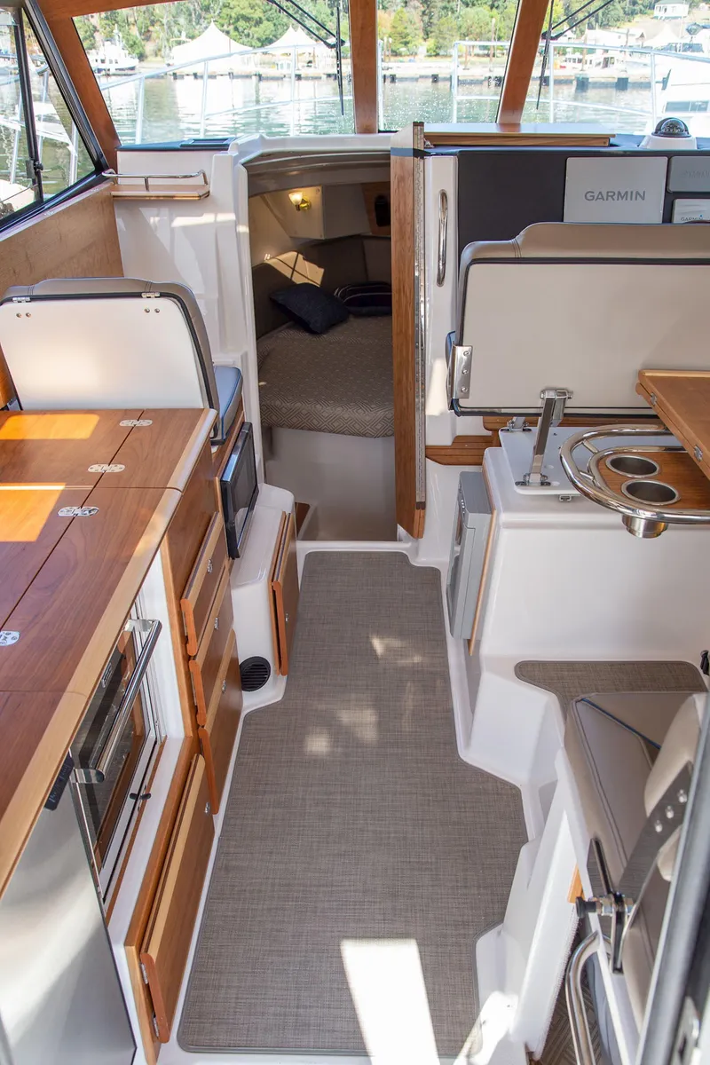 Slide: The Image of Interior of 2025 Cutwater 32 Coupe, featuring modern kitchen and cozy cabin space. - 6