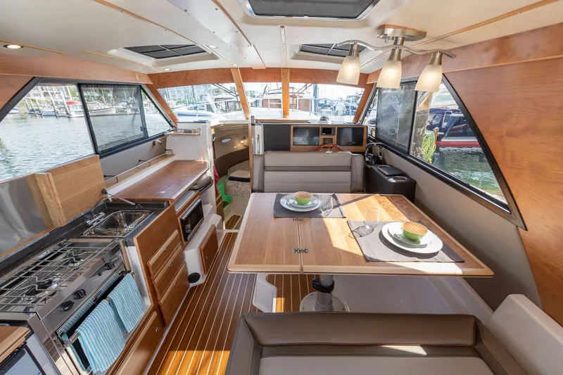 Slide: The Image of Interior of 2025 Cutwater 32 Coupe, featuring modern kitchen and dining area with waterfront view. - 9