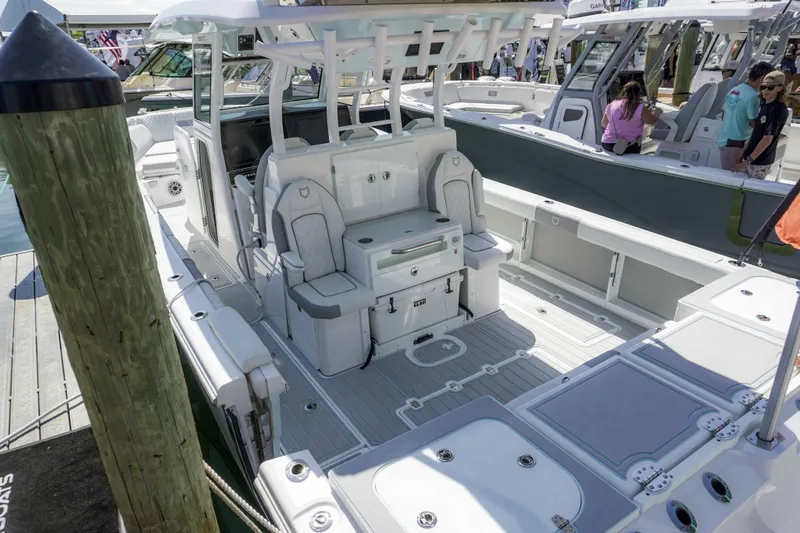 Slide: The Image of 2026 Sea Fox 368 Commander boat interior with seating and storage, docked at a marina. - 8