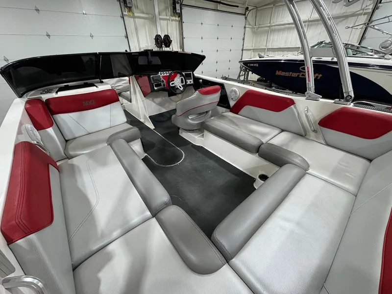 Slide: The Image of 2016 MasterCraft NXT22 boat interior with red and gray seating, sleek design, and modern dashboard. - 10