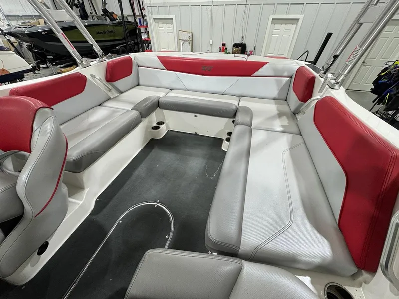 Slide: The Image of 2016 MasterCraft NXT22 boat interior with red and gray seating in a spacious layout. - 11