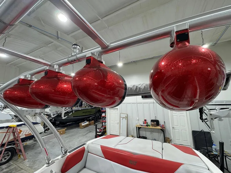 Slide: The Image of Red speakers on a 2016 MasterCraft NXT22 boat in a garage setting. - 13