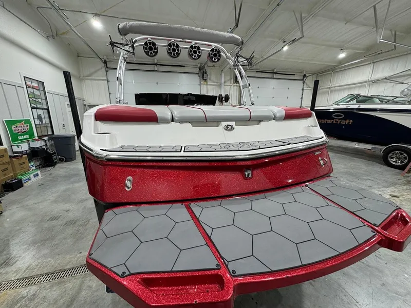 Slide: The Image of 2016 MasterCraft NXT22 boat with red and white design in a garage setting. - 2