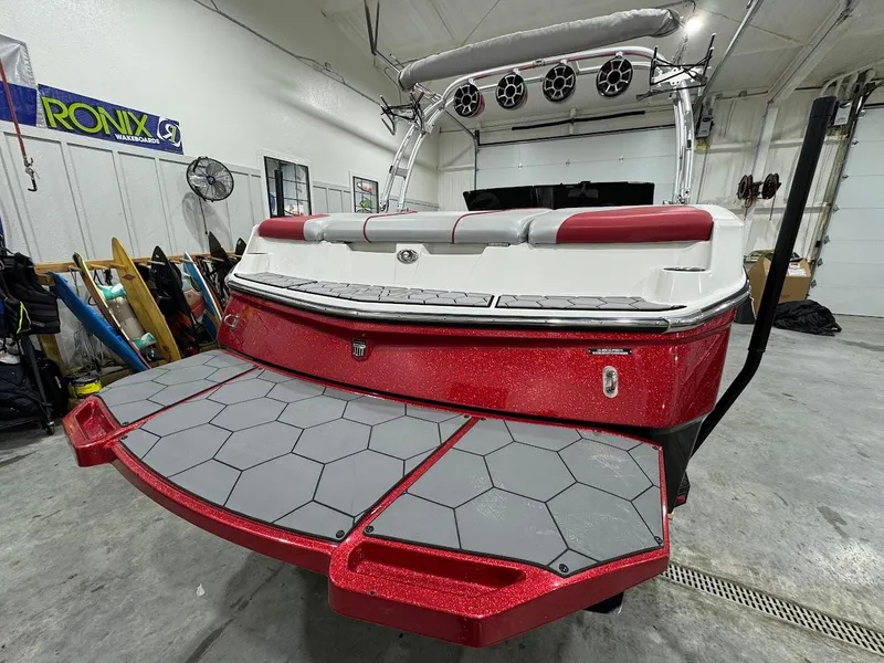 Slide: The Image of 2016 MasterCraft NXT22 boat with red and gray deck in a garage setting. - 3