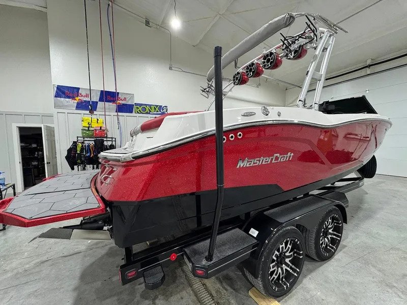 Slide: The Image of 2016 MasterCraft NXT22 boat in a showroom, red and white design, on a trailer. - 4