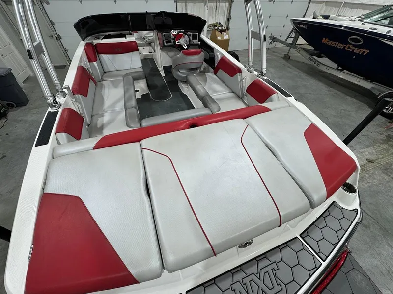 Slide: The Image of 2016 MasterCraft NXT22 boat interior with red and gray seating, showcasing spacious design. - 8