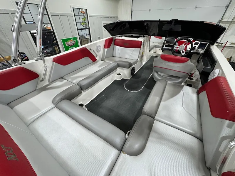 Slide: The Image of 2016 MasterCraft NXT22 boat interior with red and gray seating, modern dashboard. - 9