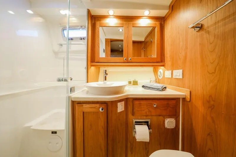 Slide: The Image of 2025 Sabre 45 Salon Express bathroom with wooden cabinetry and modern fixtures. - 7