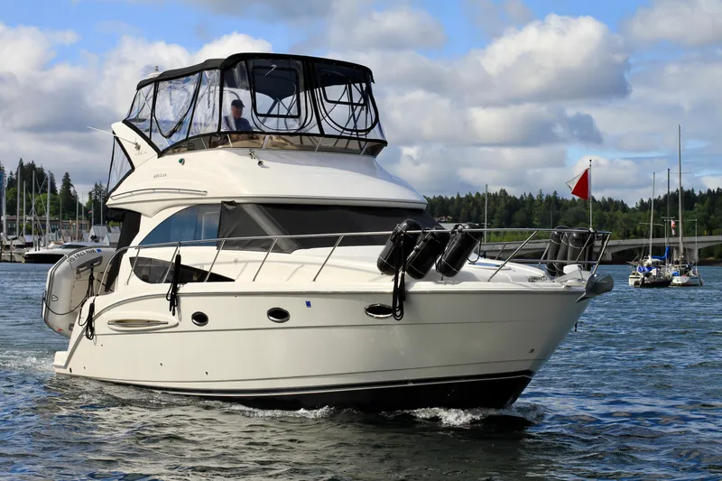 Slide: The Image of 2006 Meridian 341 Sedan yacht cruising on a scenic waterway under a partly cloudy sky. - 1