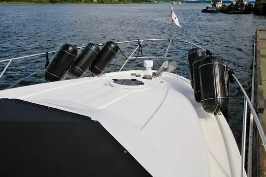 Slide: The Image of 2006 Meridian 341 Sedan yacht docked, featuring a sleek white deck and protective fenders. - 12