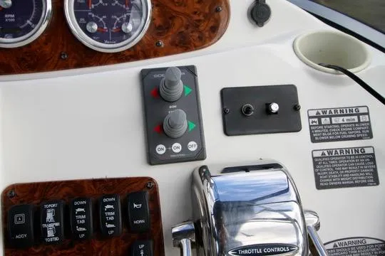 Slide: The Image of Control panel of a 2006 Meridian 341 Sedan boat with throttle and warning labels. - 28