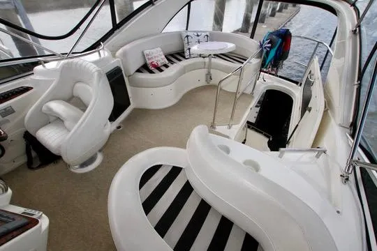 Slide: The Image of 2006 Meridian 341 Sedan interior with white seating and striped cushions, docked by the water. - 30