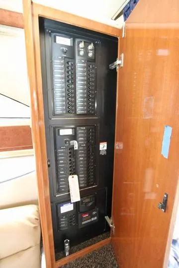 Slide: The Image of Electrical panel inside a 2006 Meridian 341 Sedan yacht, with open wooden cabinet door. - 38