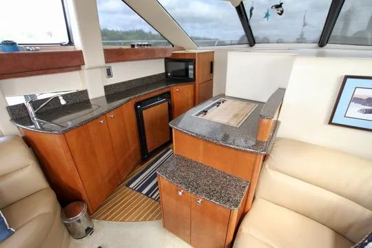 Slide: The Image of 2006 Meridian 341 Sedan yacht interior with kitchen, featuring wood cabinetry and granite countertops. - 41