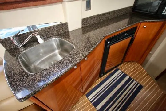 Slide: The Image of 2006 Meridian 341 Sedan kitchen with granite countertop, sink, and compact fridge. - 43