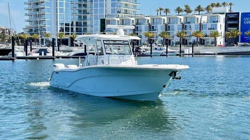 Slide: The Image of 2026 Sea Fox 368 Commander boat cruising in a marina with modern buildings in the background. - 2