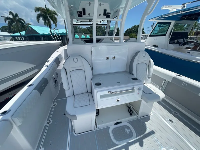 Slide: The Image of 2026 Sea Fox 368 Commander boat interior with seating and storage, docked under a sunny sky. - 24