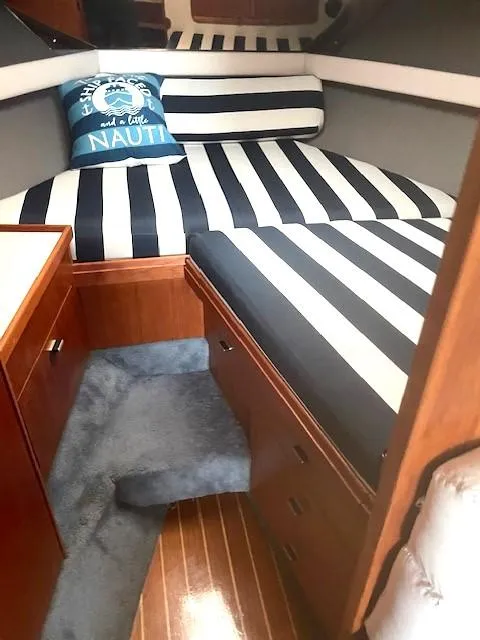 Slide: The Image of 1990 Tiara Yachts 3100 Open cabin with striped bedding and nautical decor. - 11