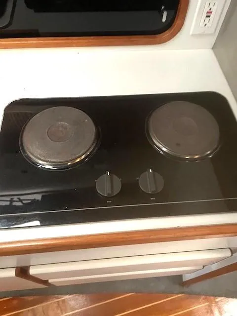 Slide: The Image of 1990 Tiara Yachts 3100 Open stove with two burners and control knobs. - 12