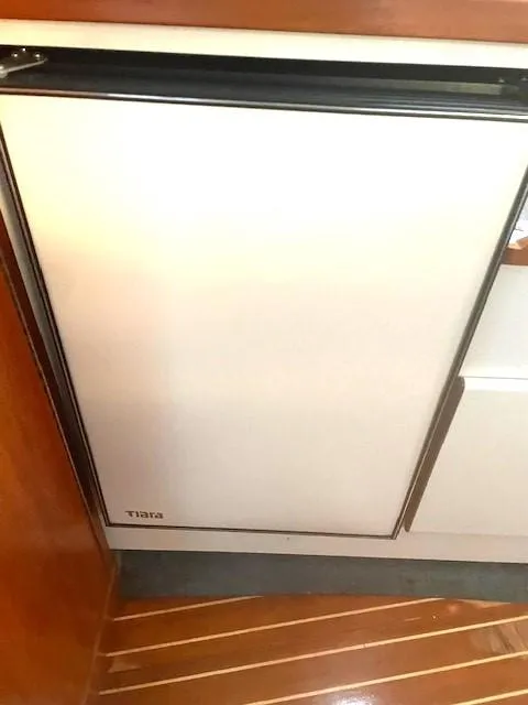 Slide: The Image of 1990 Tiara Yachts 3100 Open interior with compact refrigerator. - 13